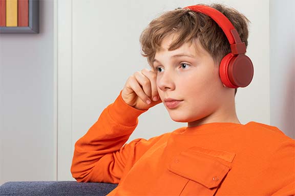 Person hört mit On-Ear-Kopfhöerern Musik.