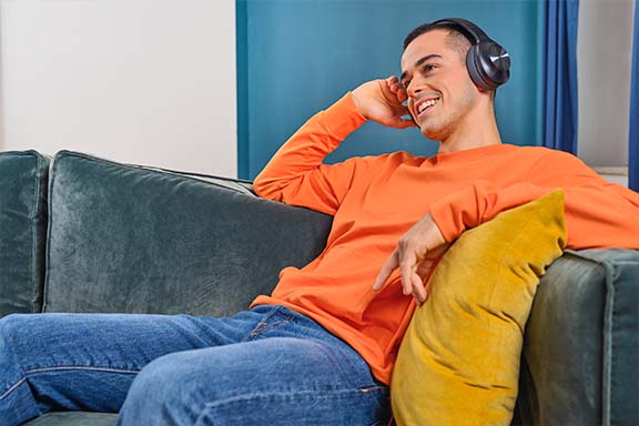 Person genießt mit Over-Ear-Kopfhörer Musik.